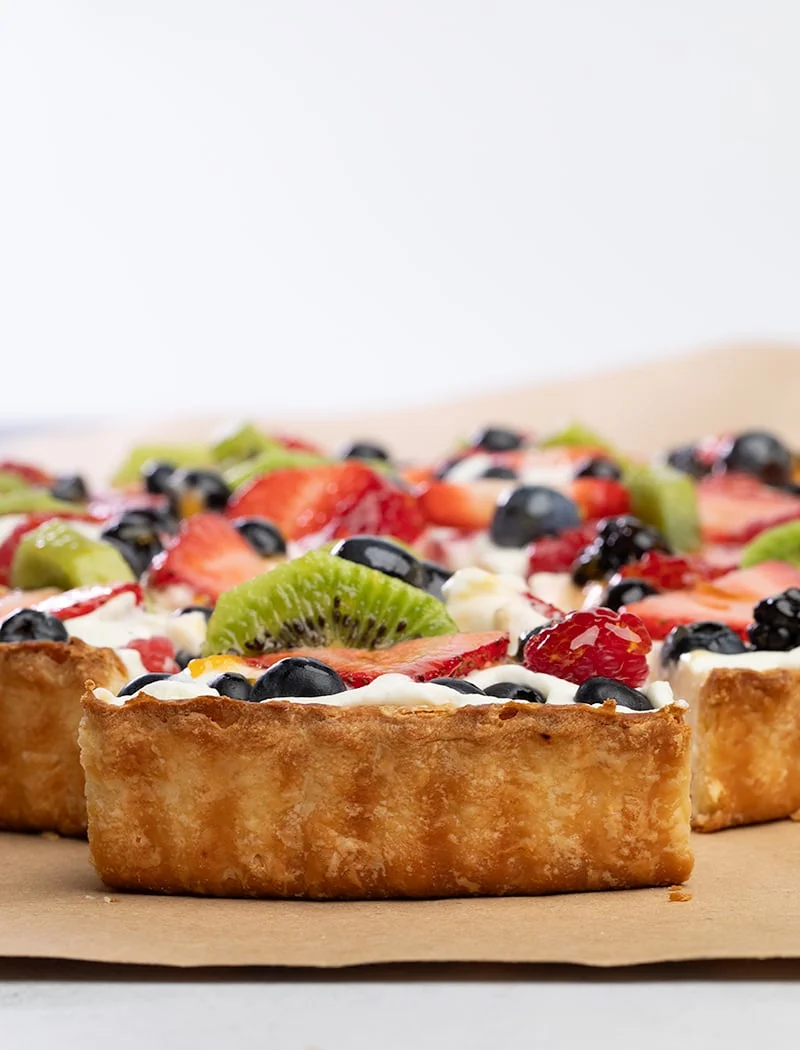 closeup image of browned back crust of slice of fruit tart on brown kraft paper