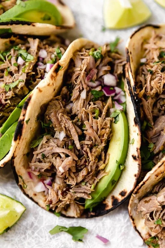 Closeup of pork carnitas taco with avocado.