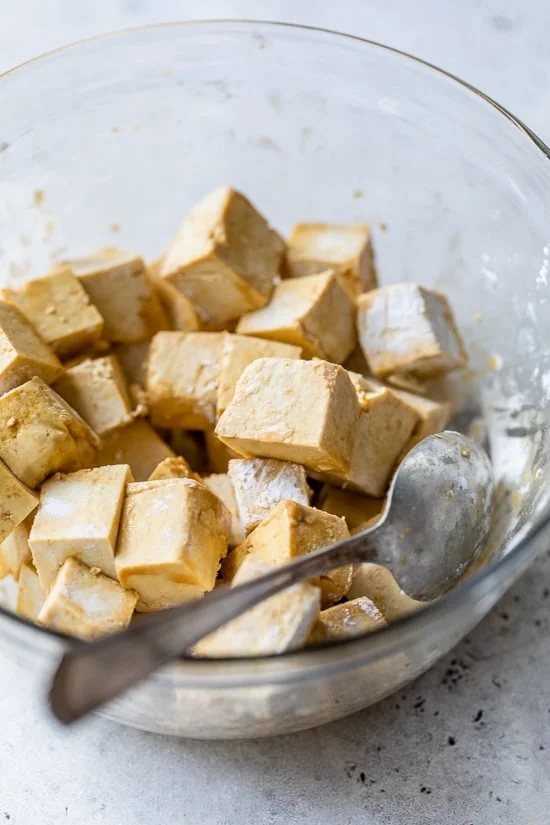 Combine tofu cubes with soy sauce and cornstarch.