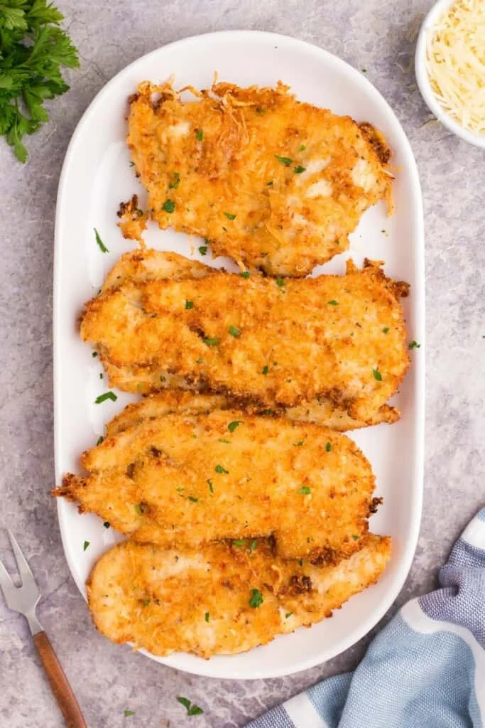 cooked air fryer parmesan chicken on a white platter 