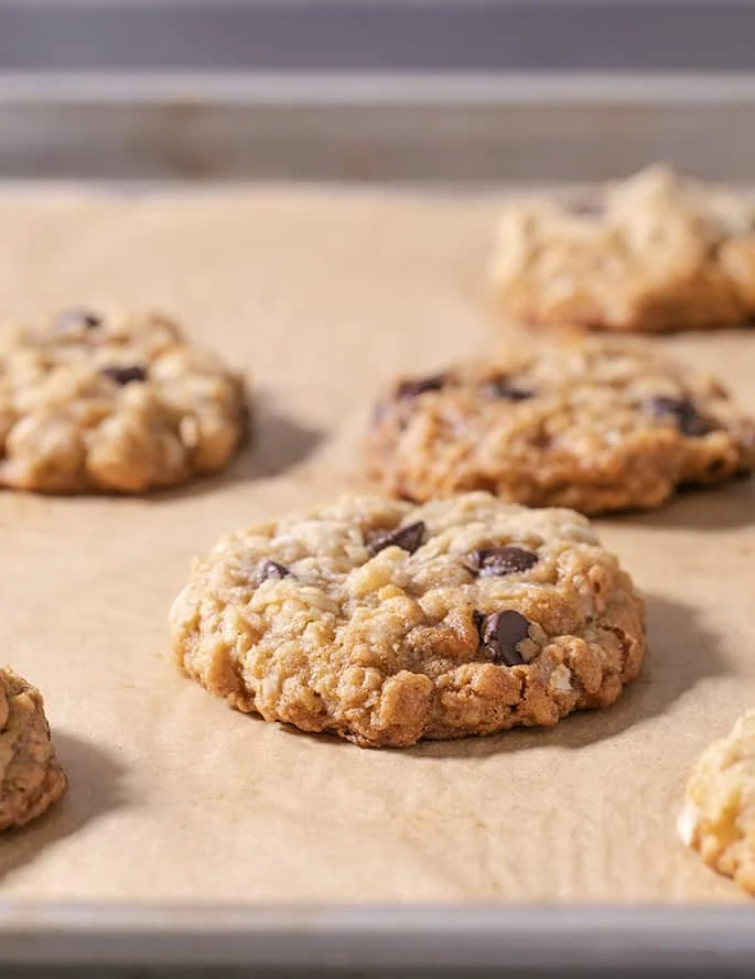 cookies with chocolate chips on brown paper that are made from a substitute for oats of flattened rice
