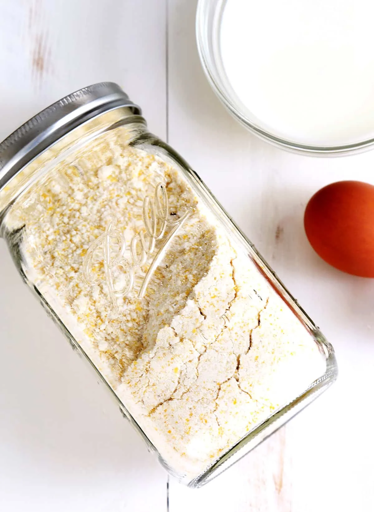 Corn muffin mix in a jar on white surface