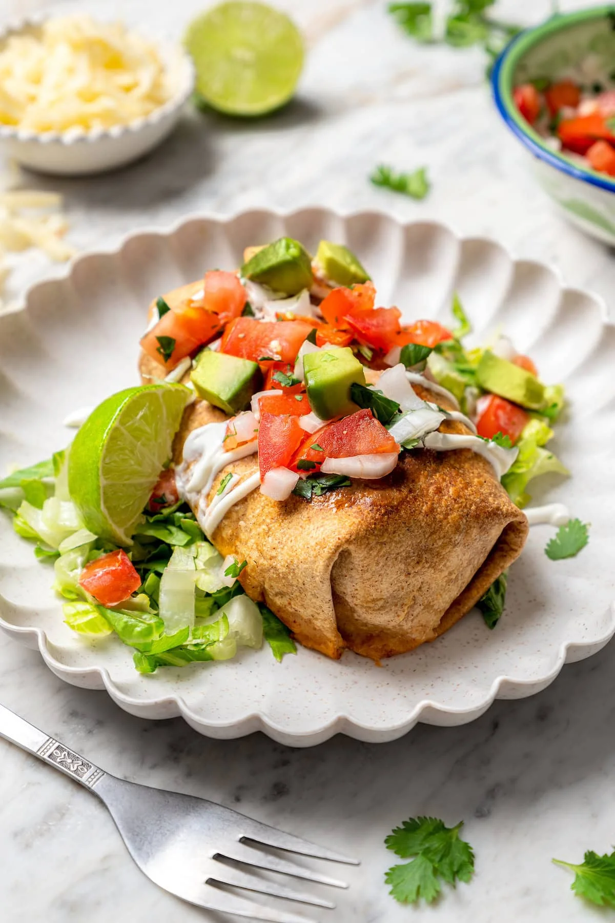 Crispy air fryer chicken chimichanga on plate with toppings