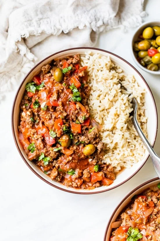 Crock Pot Picadillo is a flavorful Cuban dish made with ground beef and a sauce made from simmering tomatoes, green olives, bell peppers, cumin, and spices.