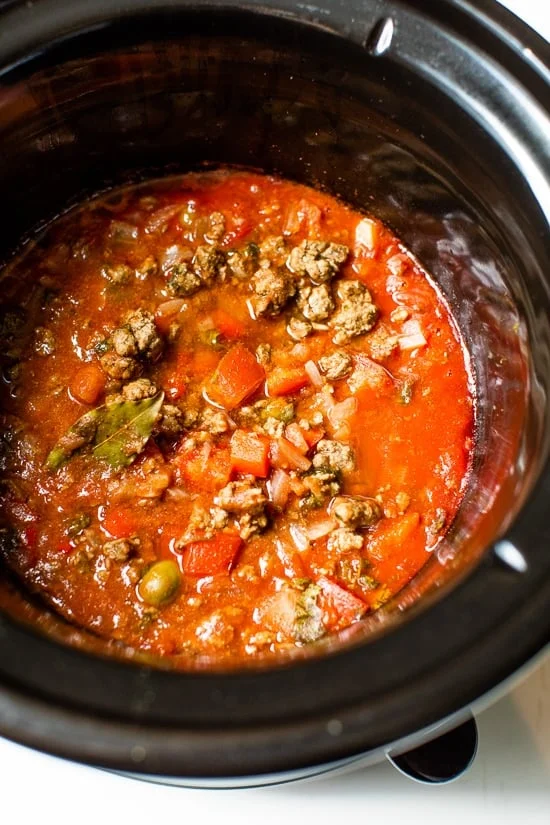 Crock Pot Picadillo is a flavorful Cuban dish made with ground beef and a sauce made from simmering tomatoes, green olives, bell peppers, cumin, and spices.
