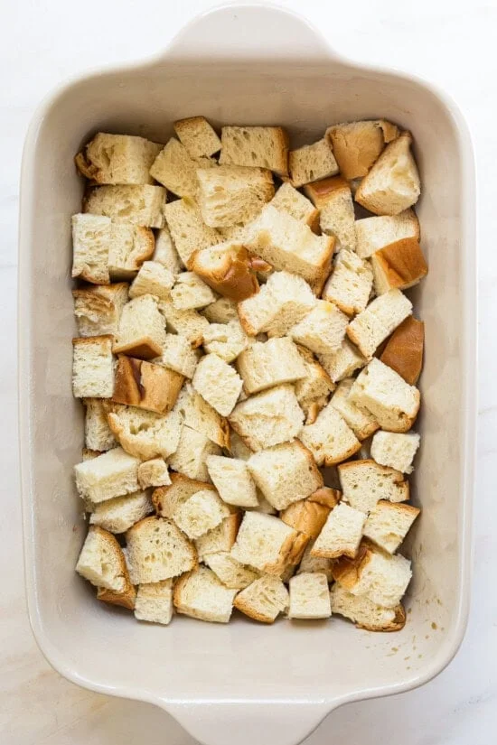 Cubes of challah bread in a casserole dish.