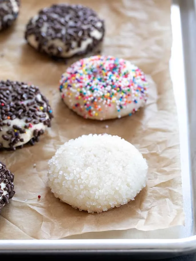 Drop sugar cookies with different toppings on a tray.