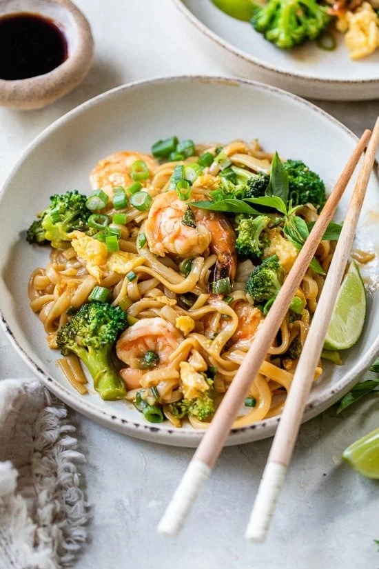 Drunken Noodles with Shrimp and chopsticks on a plate.