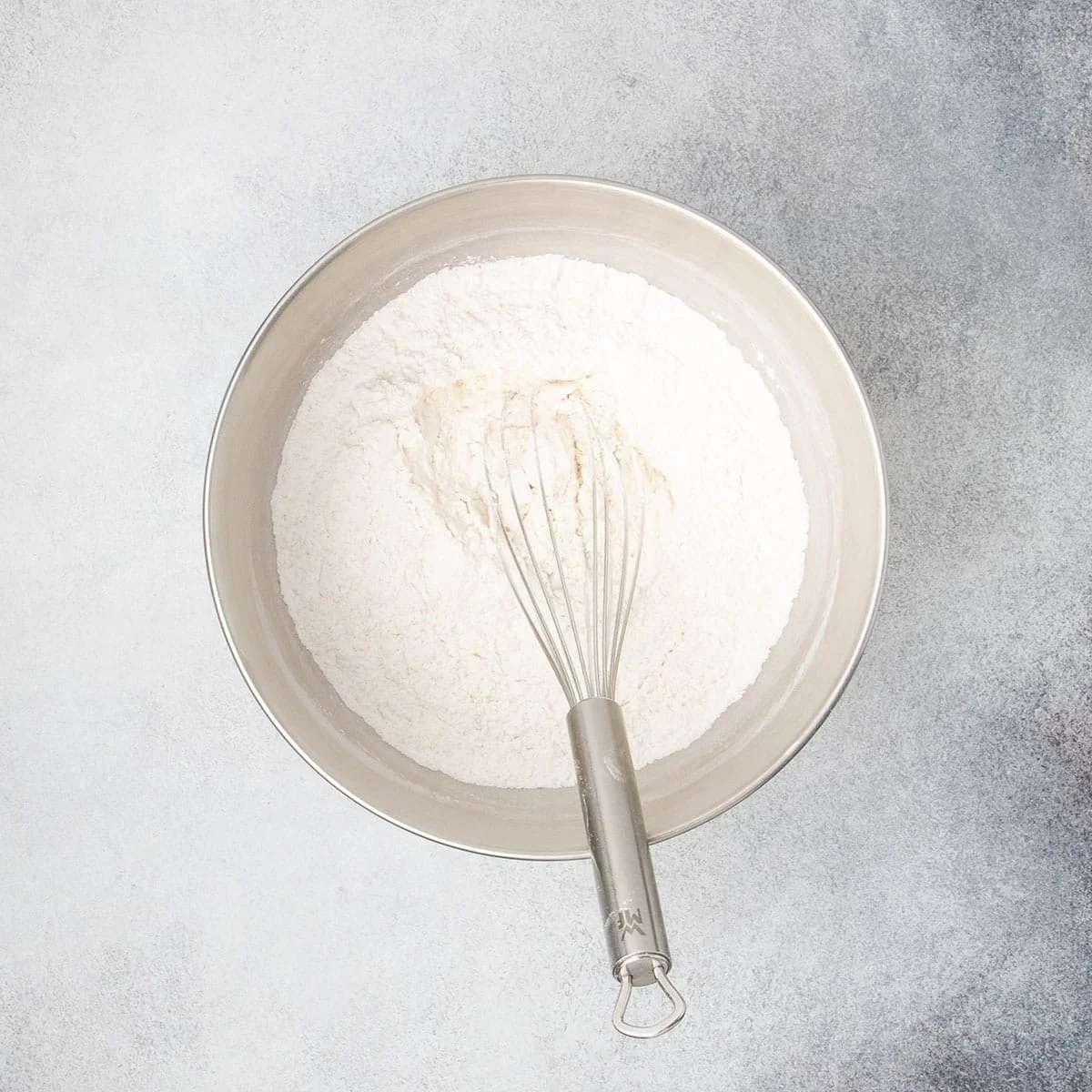 Dry ingredients for rolls whisked together in a large mixing bowl.