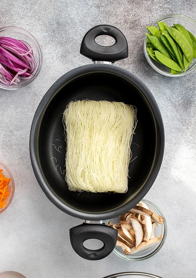 Dry nest of gluten free rice noodles in black pan