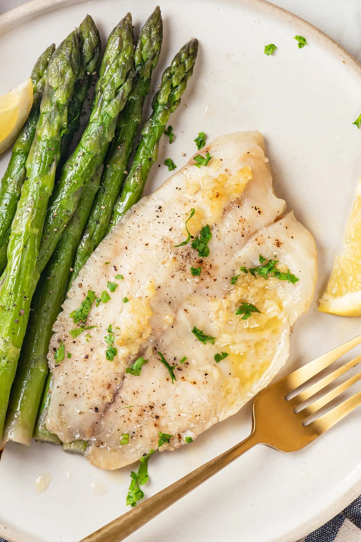 Easy baked tilapia on plate with asparagus