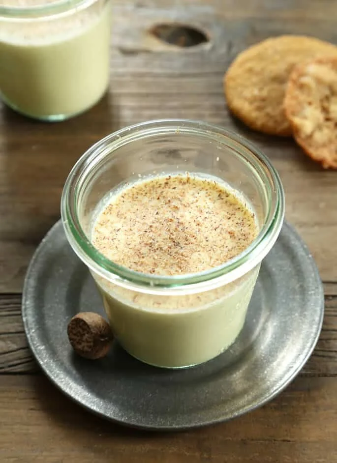 Egg nog in a jar on a white plate 