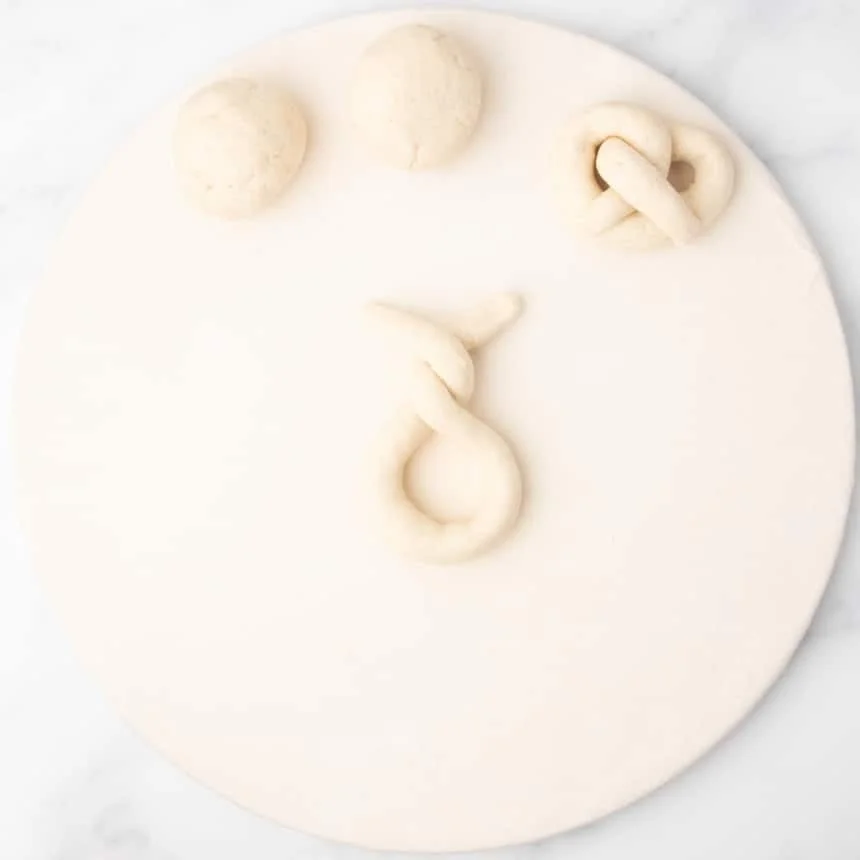 end pieces of crossed loop of rope of raw dough crisscrossed again over one another