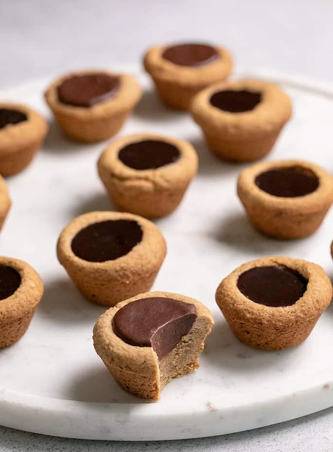 Fudge puddles on marble platter with one missing a fake bite