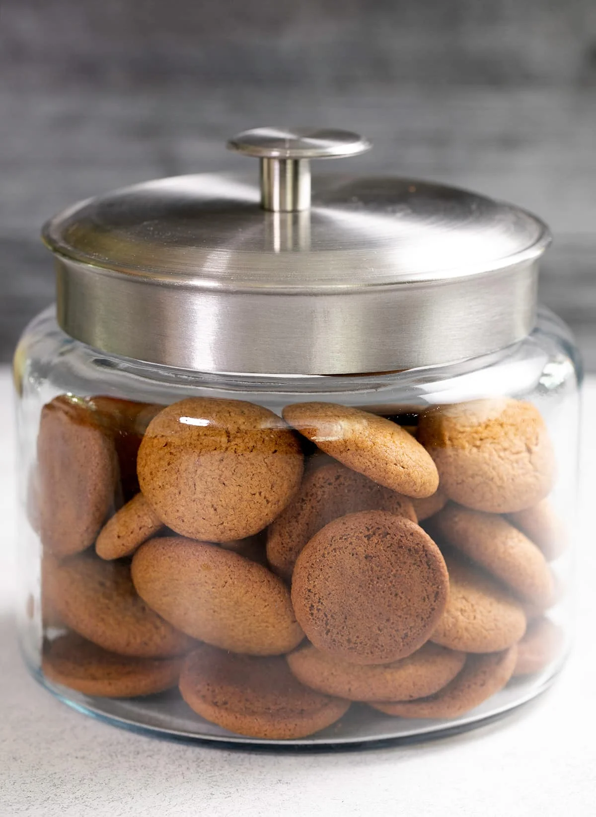 Gingersnaps in a large glass jar with a silver colored lid