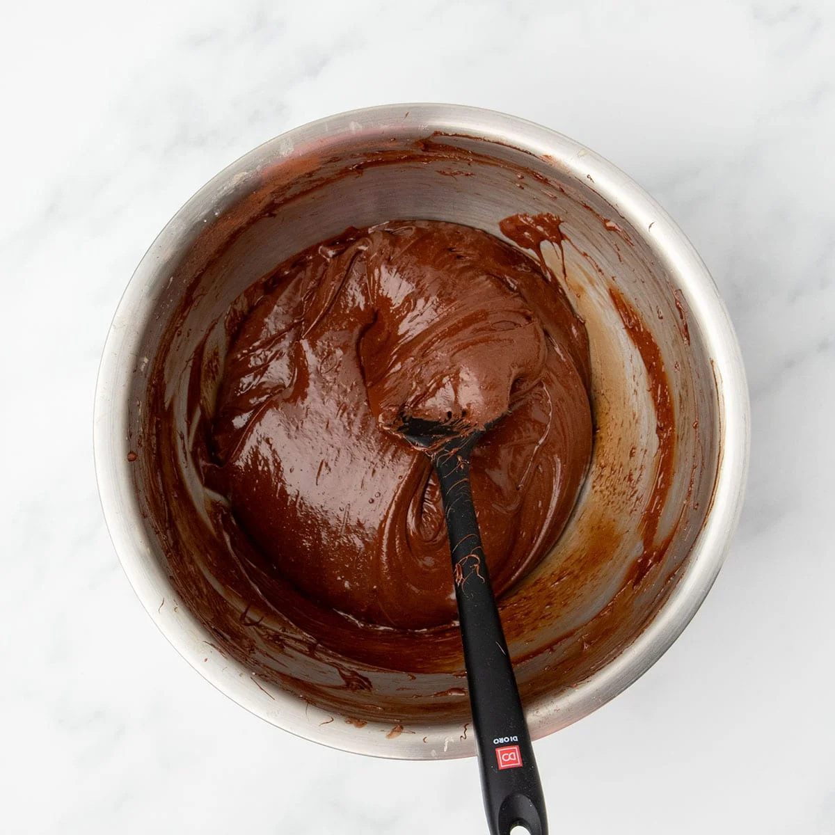 Glossy, thick brownie batter with melted chocolate mixed in and folded smooth, ready to pour into the baking pan