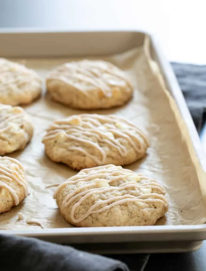 Gluten free apple pie cookies baked on tray and drizzled with icing.