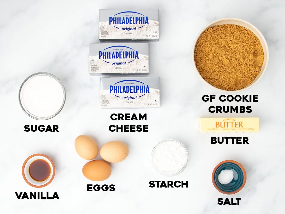 gluten free cheesecake ingredients in small bowls with black block lettering with name of each ingredient