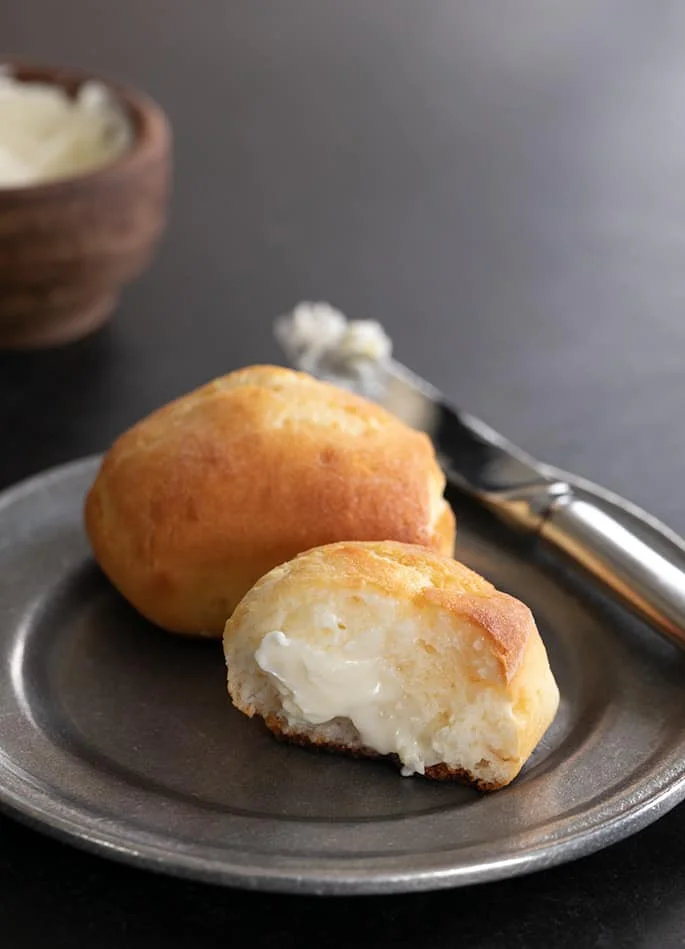 Gluten free Texas roadhouse rolls plated, showing the crumb inside of one roll.