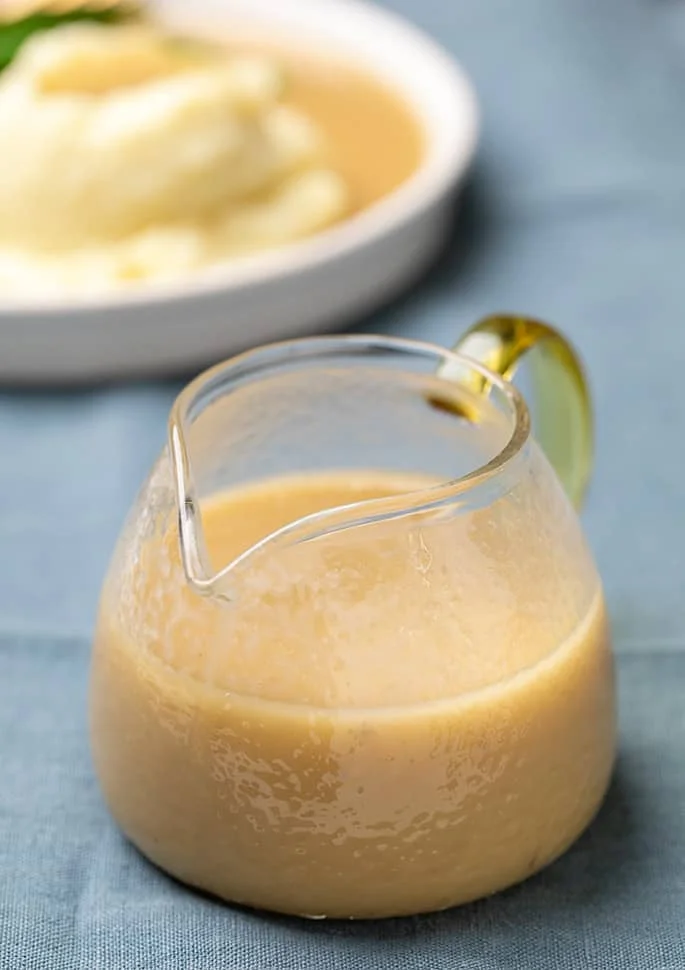 Gravy in small upright glass gravy boat. 