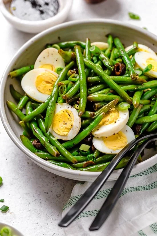 Green bean salad in bowl with two forks.