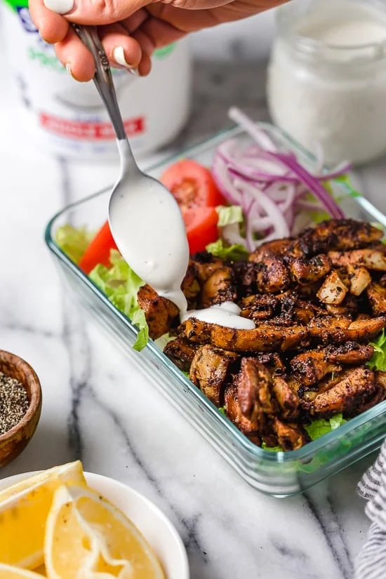 Halal Food Cart inspired chicken served over a big salad of lettuce and tomatoes drizzled with a yummy white sauce.