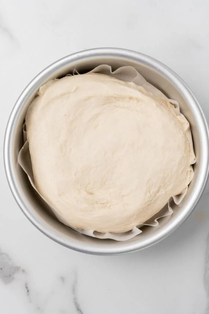 Homemade bread dough continuing to rise in mixing bowl.