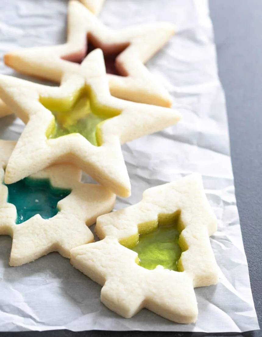 Image of pile of stained glass gluten free sugar cookies shaped like stars and Christmas trees