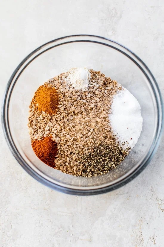 Ingredients for bran flake chicken coating in glass bowl before stirring.