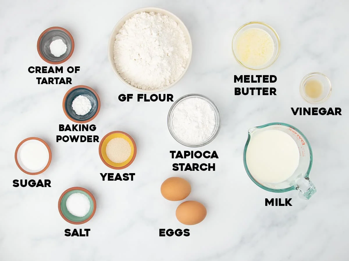 ingredients for gluten free bread machine recipe in small bowls with black block letters spelling name of each ingredient