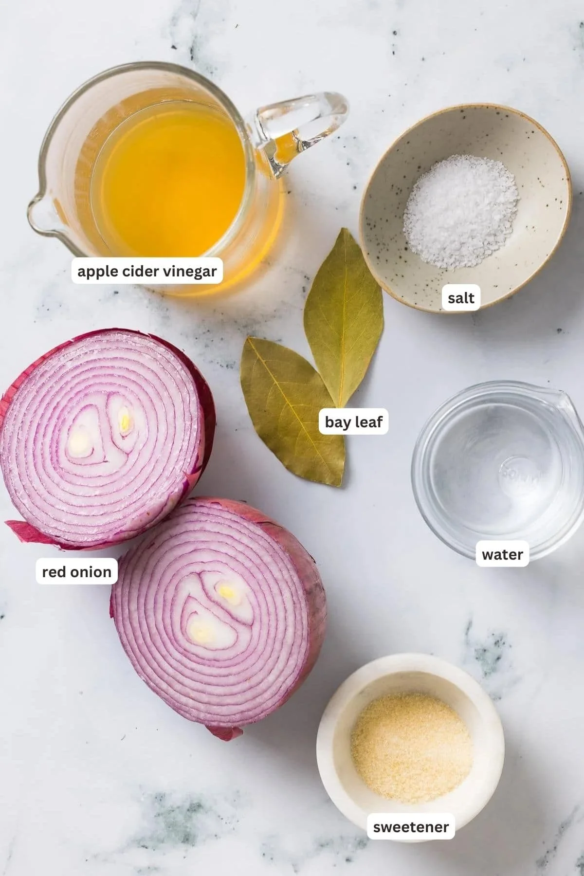 Ingredients for pickled red onions on a marble counter.