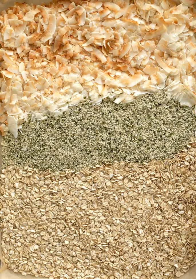 ingredients for protein balls being toasted on baking sheet