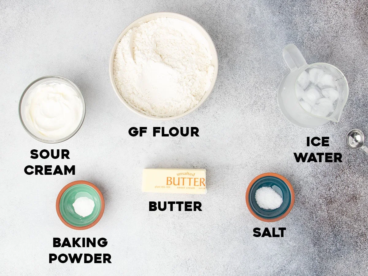 Ingredients for the pie crust in small bowls with black block letters spelling out the name of each ingredient.