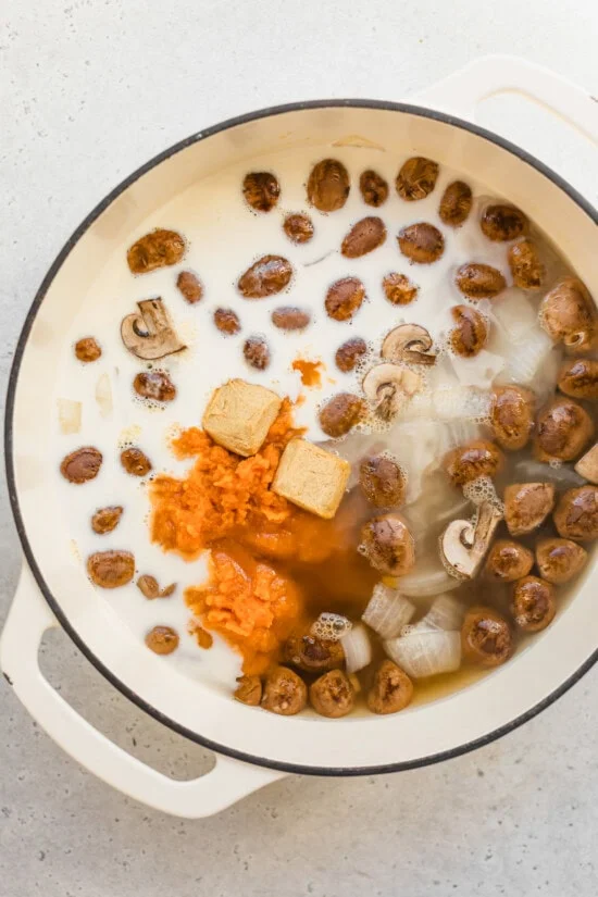 Ingredients in a pot for pumpkin soup with canned pumpkin, ginger, and coconut milk