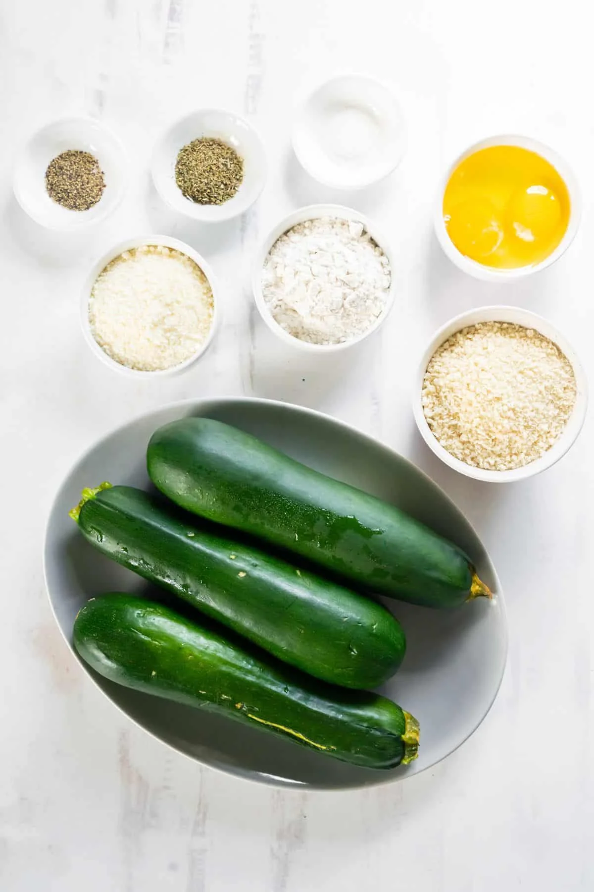 Ingredients needed to make air fryer zucchini fries: summer zucchini, eggs, panko, parmesan cheese, italian seasoning, flour, salt, and pepper.