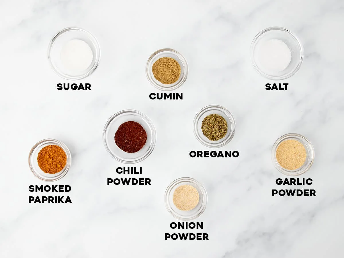 ingredients of gluten free taco seasoning in small bowls with black lettering stating names of each ingredient