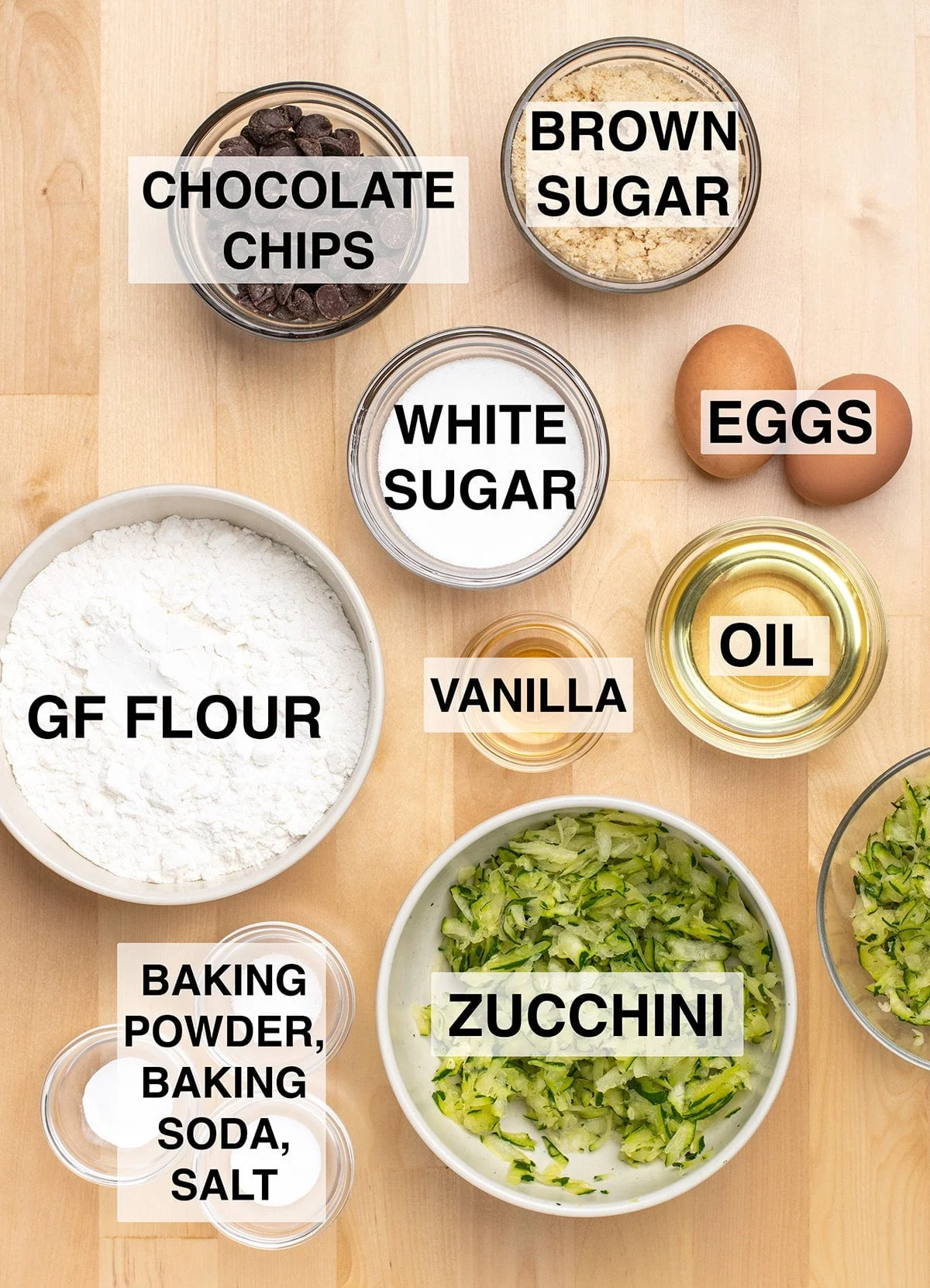 Ingredients required to make the recipe prepared in round glass and ceramic bowls on light wood surface. 