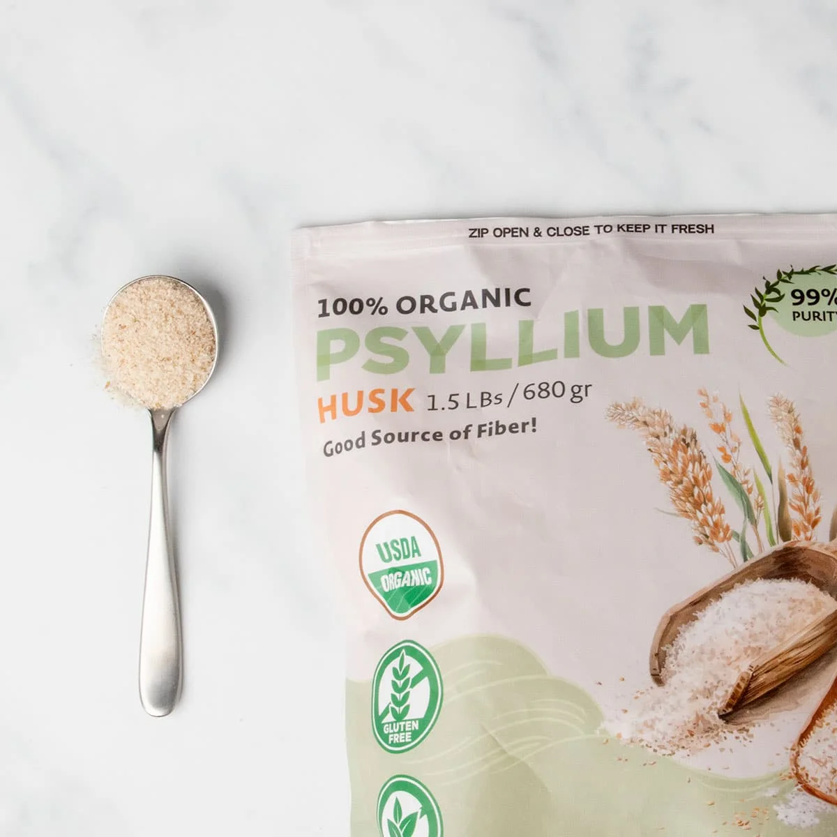 light brown and green package of whole psyllium husk with sample of light brown dry flakes on large metal spoon