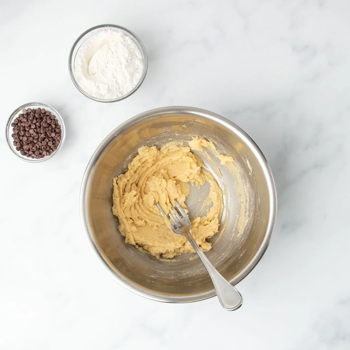 Light brown mixture of soft butter and sugars in a bowl.