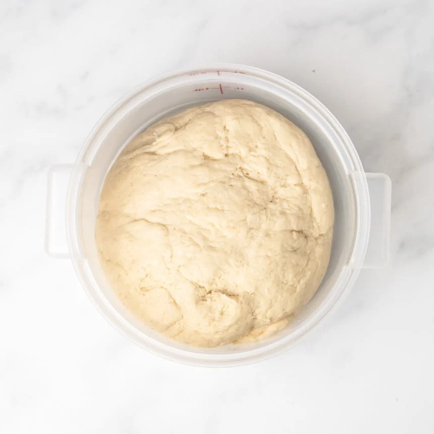 light tan raw soft pretzel bread dough in 2 quart plastic proofing bucket