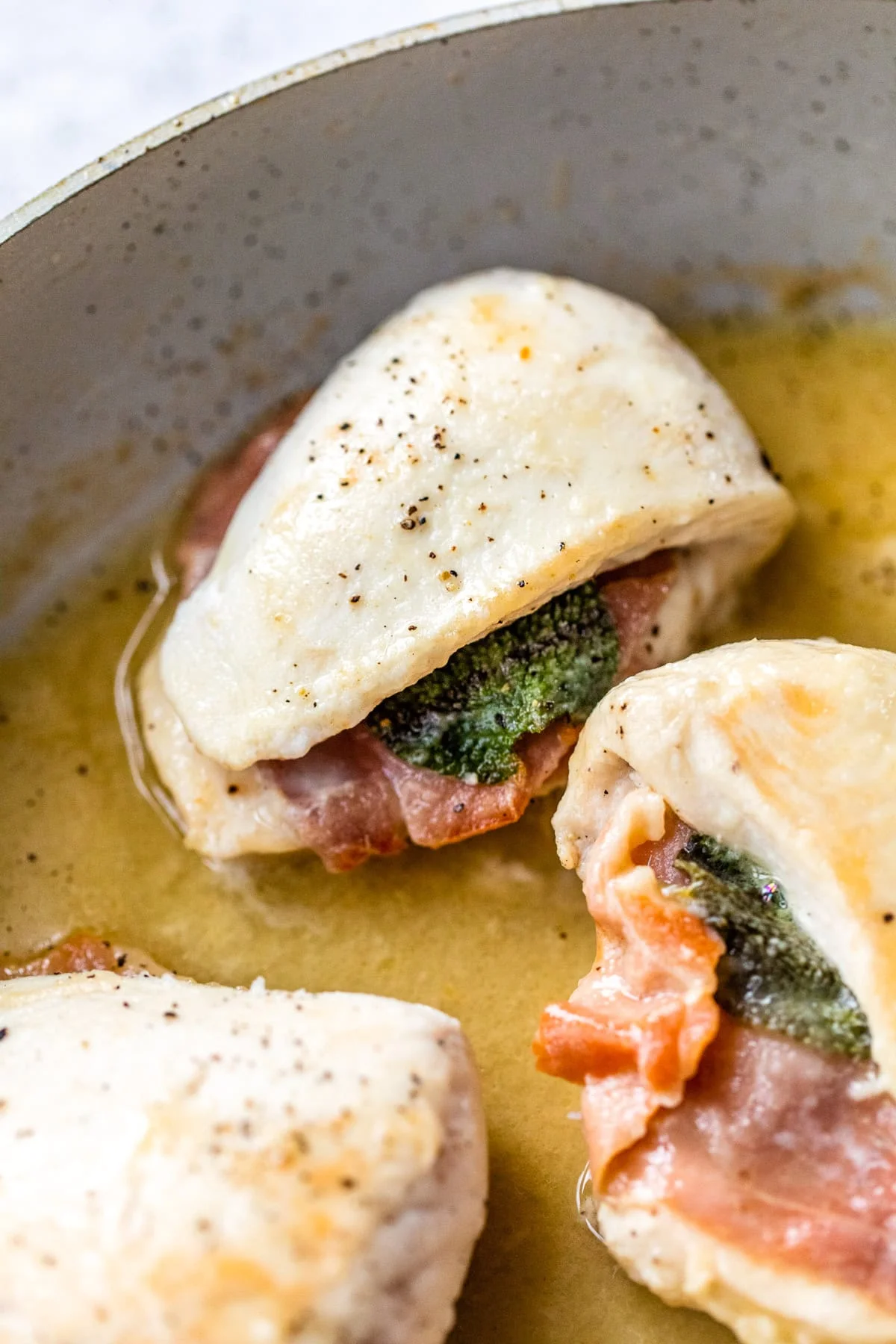 Lightened up chicken saltimbocca cooking in skillet