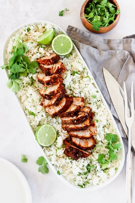 Mexican Adobo Pork Tenderloin with rice on a platter