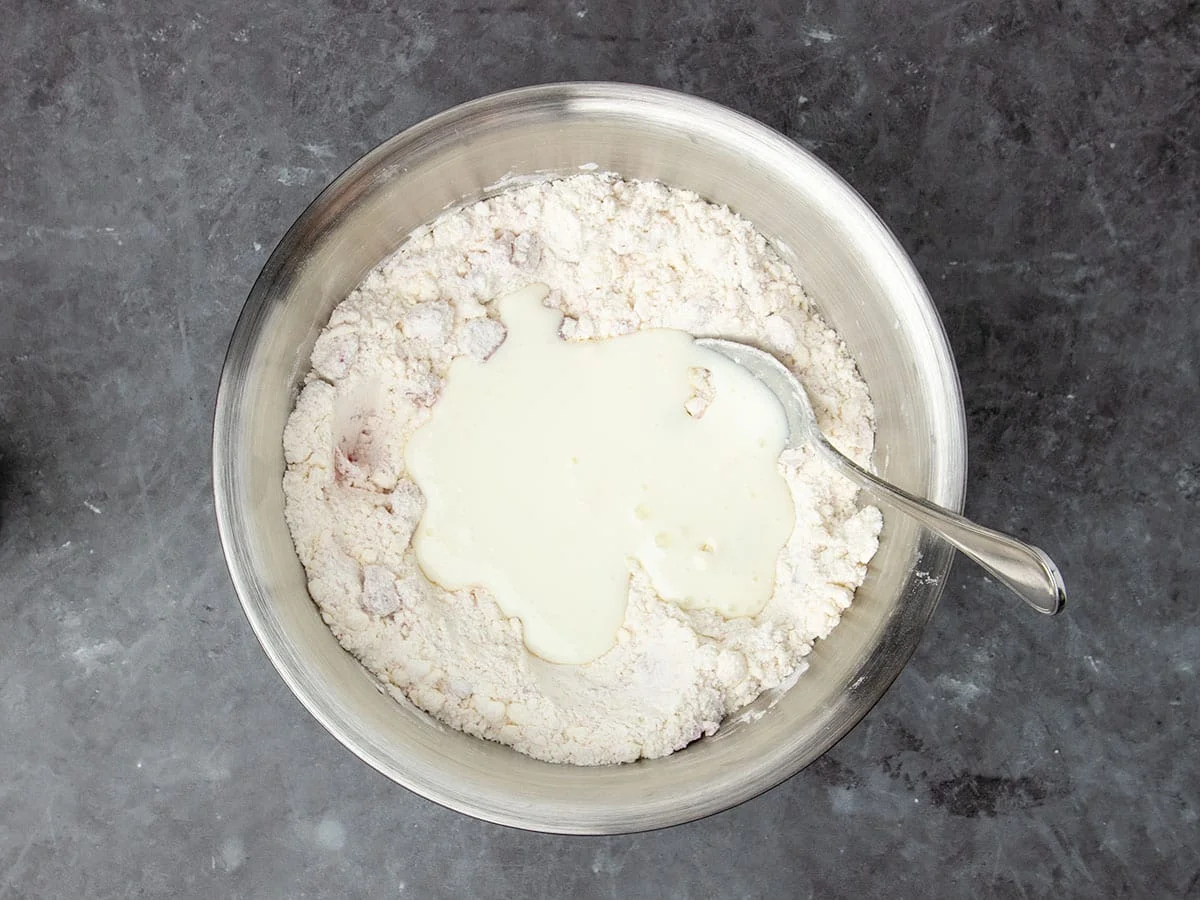mixture in same bowl with white liquid buttermilk on top