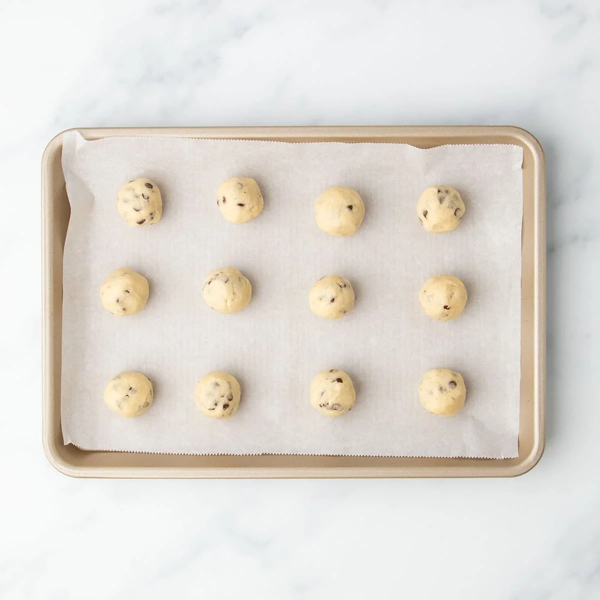 Neatly formed dough portions arranged on a baking tray.