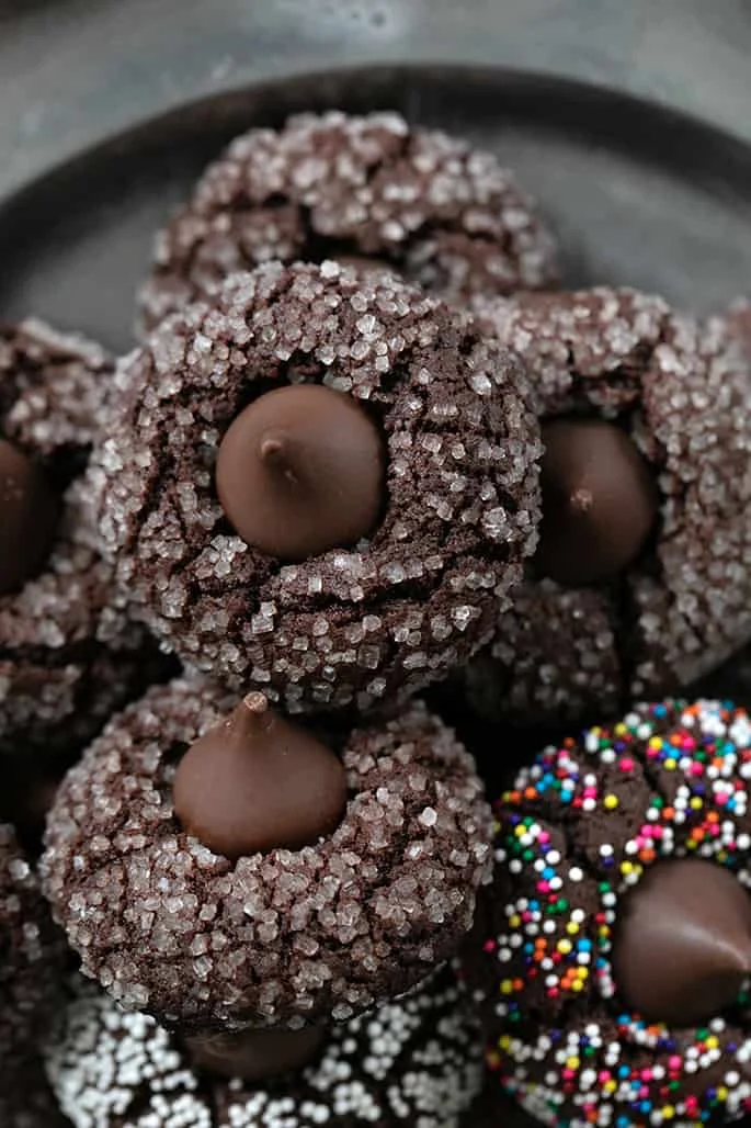 Overhead closeup image of a pile of gluten free chocolate kiss cookies on a platter.