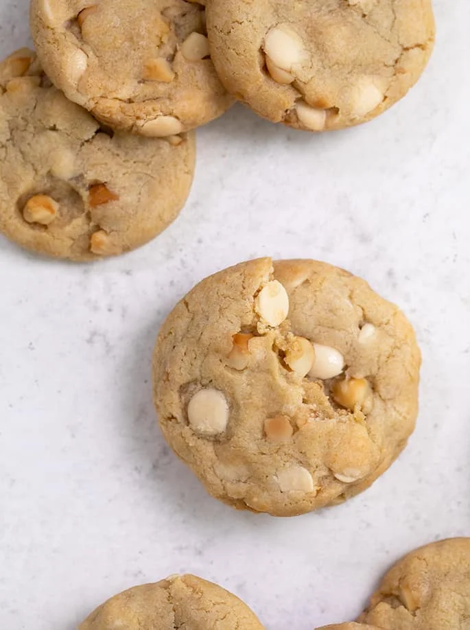 Overhead image of array of white chocolate macadamia nut cookies.
