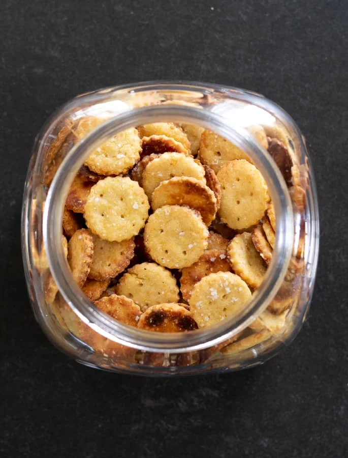Overhead image of gluten free Parmesan crackers in a large jar.