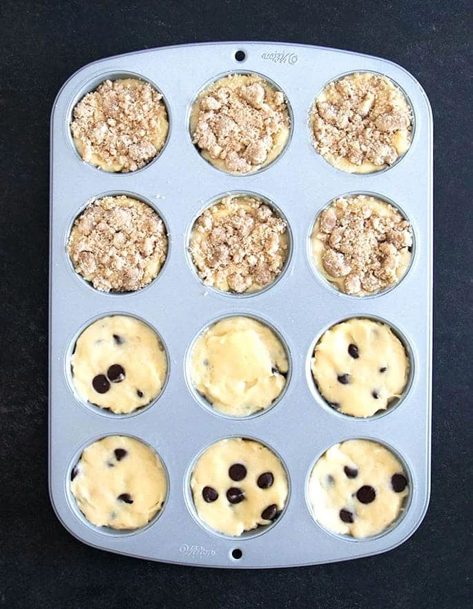 Overhead image of muffin batter with different toppings in a muffin tin
