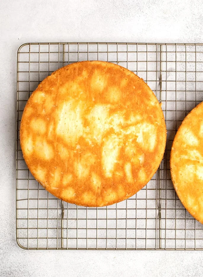 Overhead image of round gluten free yellow cake on wire rack