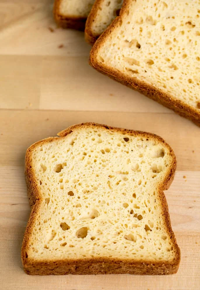Overhead image of slice of potato bread on blond wood board.